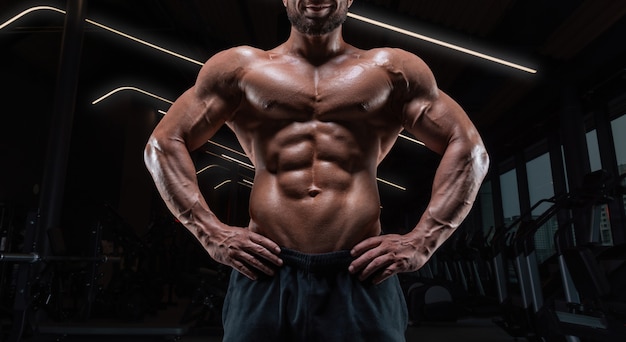 Imagen de un chico musculoso con el torso desnudo y los abdominales. Gimnasio. Concepto de fitness