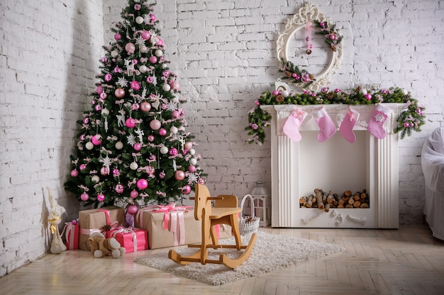 Imagen de chimenea y árbol de navidad decorado con regalo