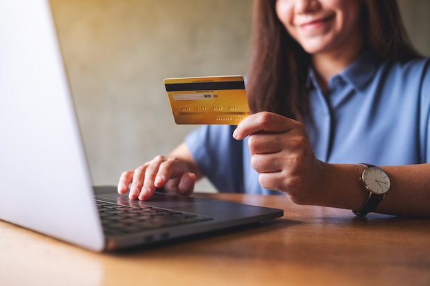 Imagen de cierre de una mujer de negocios con tarjetas de crédito mientras usa una computadora portátil para el pago en línea