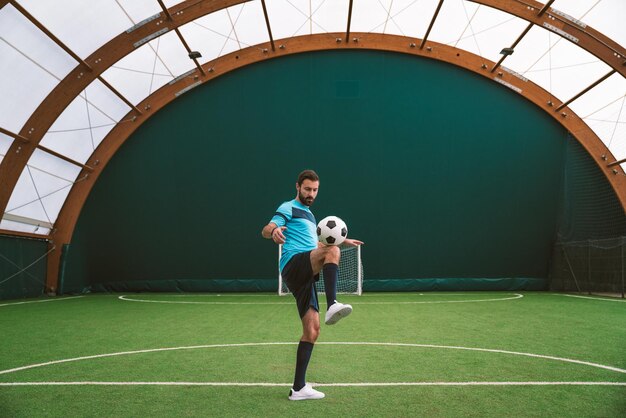 Imagen cinematográfica de un jugador de fútbol de estilo libre haciendo trucos con la pelota