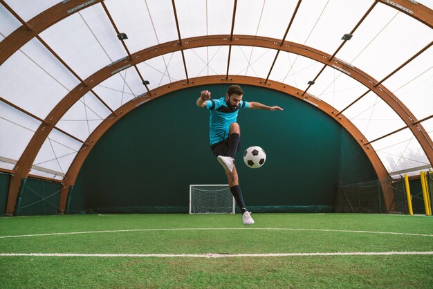 Imagen cinematográfica de un jugador de fútbol de estilo libre haciendo trucos con la pelota