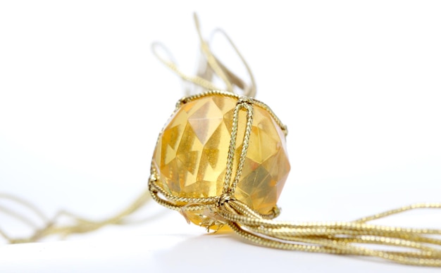 Imagen de un collar con gemas de plástico baratas y una cuerda de color dorado.