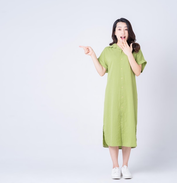 Imagen completa de una joven asiática con un vestido verde en el fondo