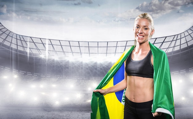 Imagen compuesta de atleta con bandera brasileña envuelta alrededor de su cuerpo