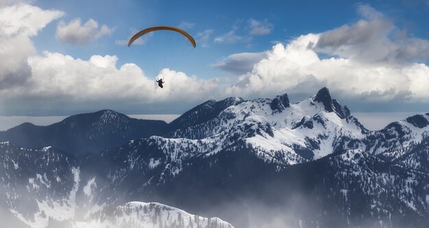 Foto imagen compuesta de aventura de parapente volando alto en las montañas rocosas