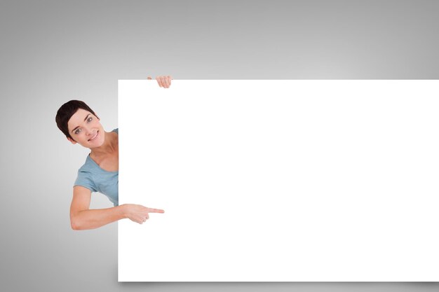 Imagen compuesta de bonita morena mostrando tarjeta tarjeta blanca