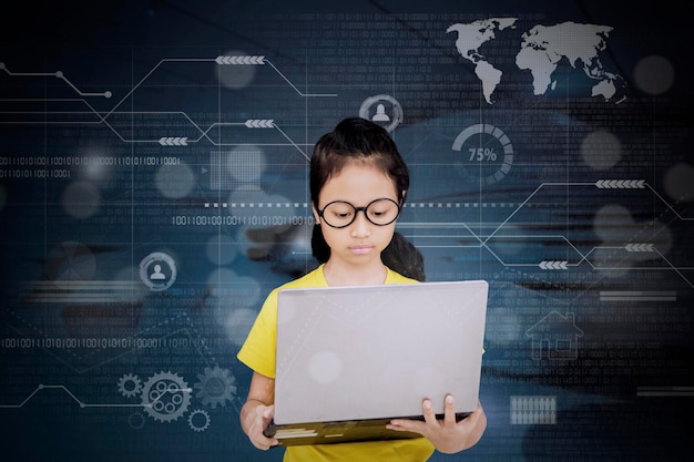 Imagen compuesta digital de una chica seria usando una computadora portátil con iconos
