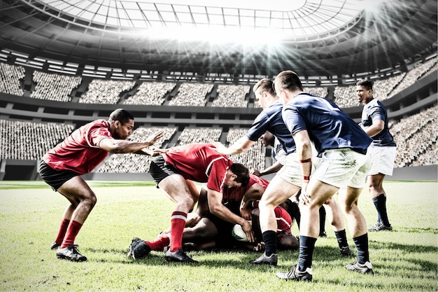 Imagen compuesta digital del equipo de jugadores de rugby que se enfrentan entre sí para ganar el balón en los estadios deportivos