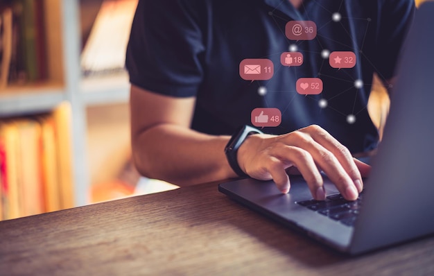 Foto imagen compuesta digital de un hombre por varios iconos usando una computadora portátil en la mesa