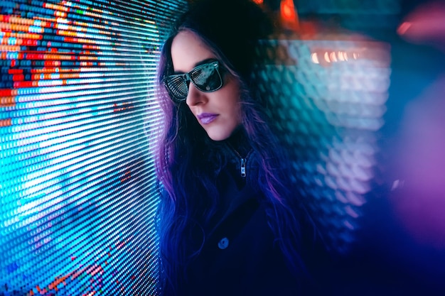 Imagen compuesta digital de una mujer contra una iluminación abstracta