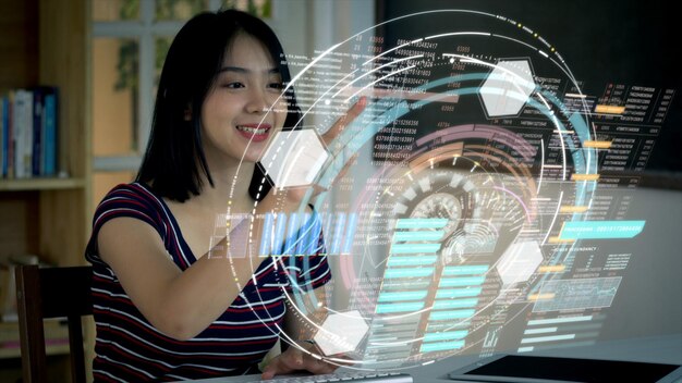 Imagen compuesta digital de una mujer joven sonriente usando una computadora mientras está sentada en la mesa