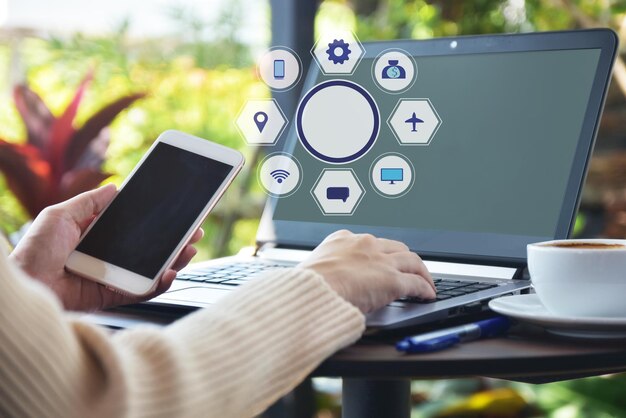 Foto imagen compuesta digital de una mujer usando una computadora portátil y un teléfono móvil en la mesa