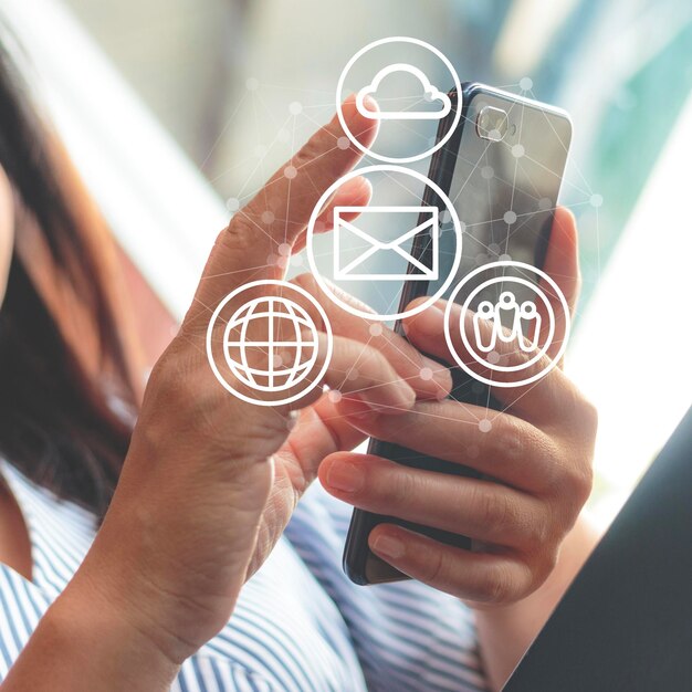 Foto imagen compuesta digital de una mujer usando un teléfono inteligente con símbolos