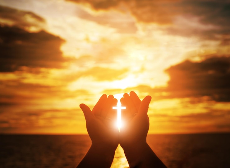 Foto imagen compuesta digital de la silueta de una mano sosteniendo la luz del sol cruzada contra el cielo