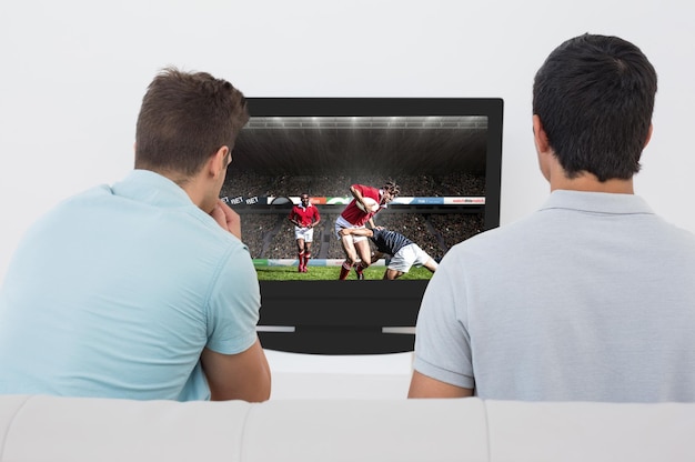 Imagen compuesta de dos aficionados al fútbol viendo la televisión