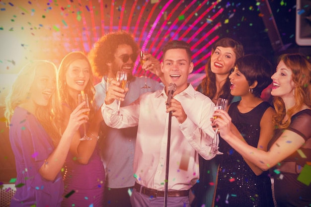 Imagen compuesta de un grupo de amigos cantando juntos en el bar