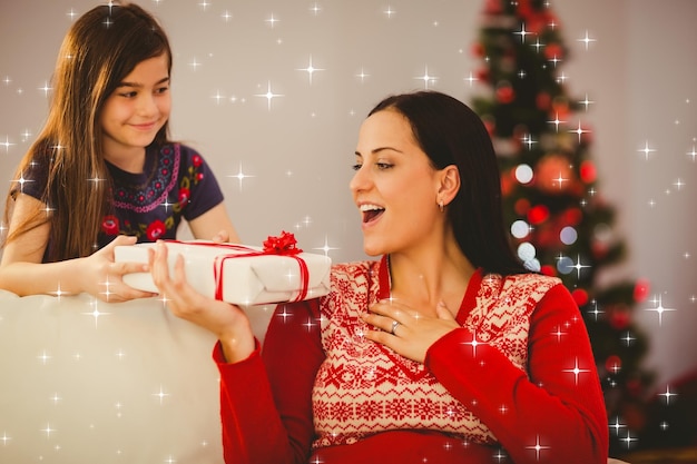 Imagen compuesta de hija dando a su madre un regalo de navidad