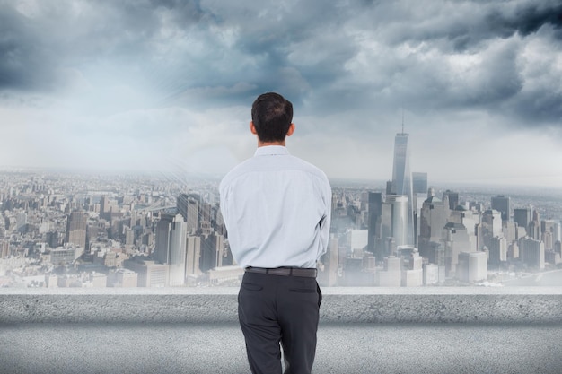 La imagen compuesta del hombre de negocios está mirando el paisaje urbano