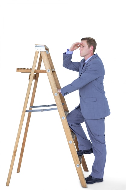 Foto imagen compuesta del hombre de negocios que se coloca en la mirada de la escalera