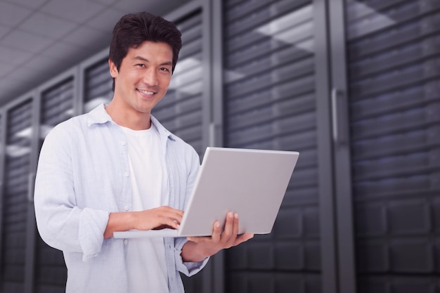 Imagen compuesta de hombre sonriente con su laptop