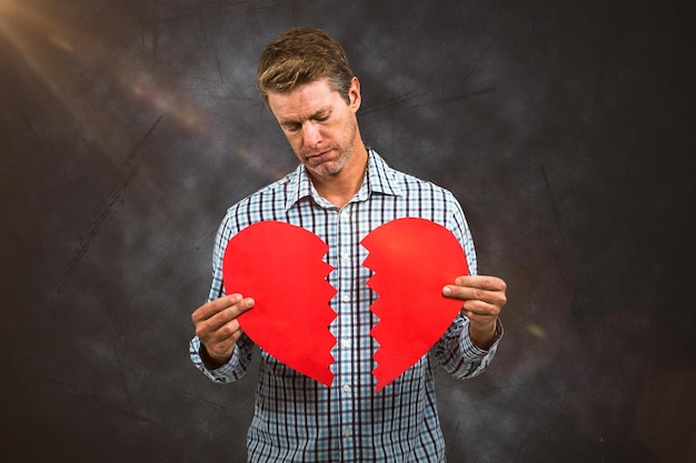 Foto imagen compuesta de hombre triste sosteniendo una tarjeta rota