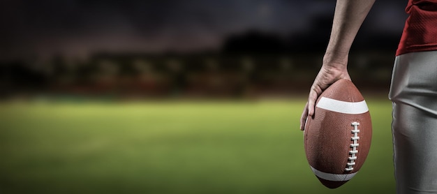 Imagen compuesta de imagen recortada del jugador de fútbol americano sosteniendo la pelota