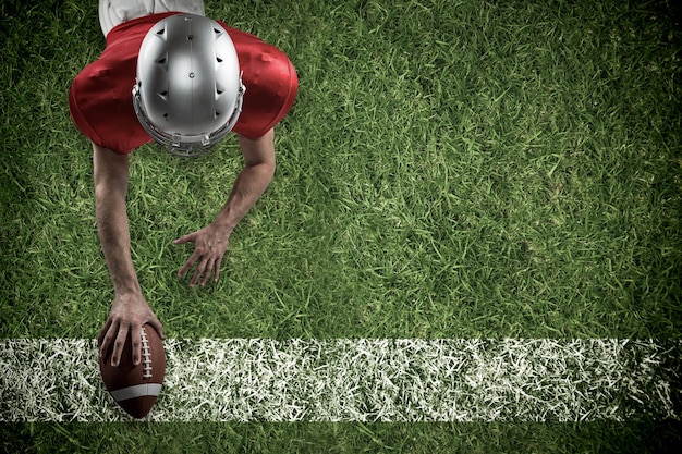 Imagen compuesta de jugador de fútbol americano tumbado delante con balón