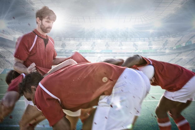 Imagen compuesta de jugadores de rugby masculinos jugando rugby en el suelo