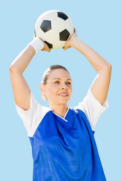 Foto imagen compuesta de mujer futbolista sosteniendo un balón