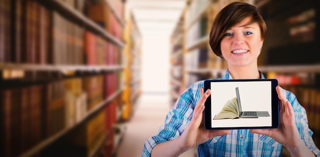 Imagen compuesta de mujer sonriente mostrando tableta digital con pantalla en blanco