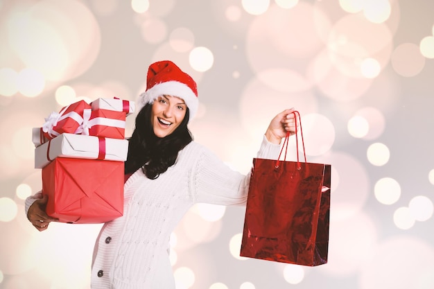 Foto imagen compuesta de mujer sonriente con regalos de navidad