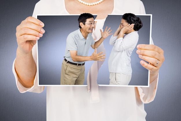 Imagen compuesta de mujer sosteniendo una foto rota