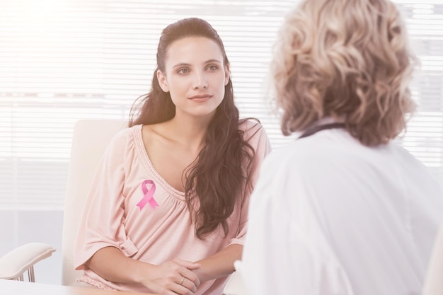 Imagen compuesta de paciente femenino escuchando al médico con concentración en el consultorio médico