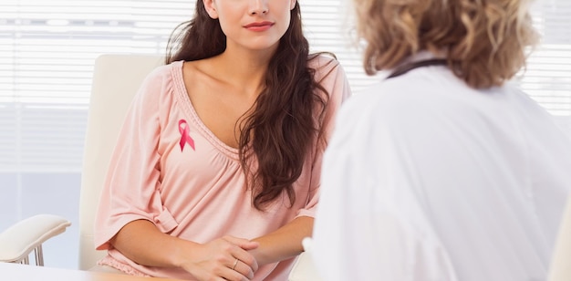 Imagen compuesta de paciente femenino escuchando al médico con concentración en el consultorio médico