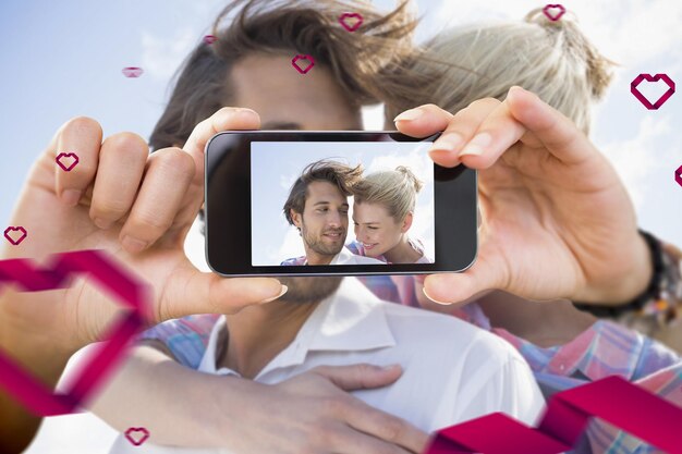 Imagen compuesta de pareja de San Valentín tomando un selfie