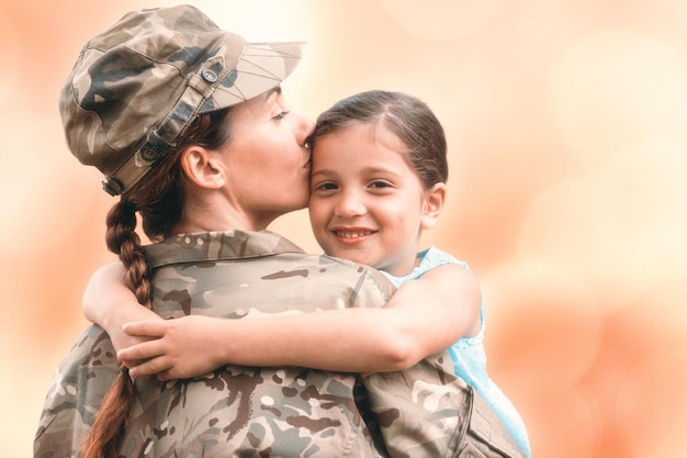 Imagen compuesta de primer plano de la madre en uniforme del ejército besando a su hija