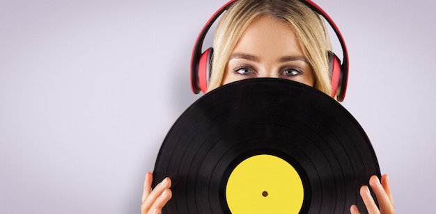 Imagen compuesta de retrato de una bella mujer sosteniendo un vinilo