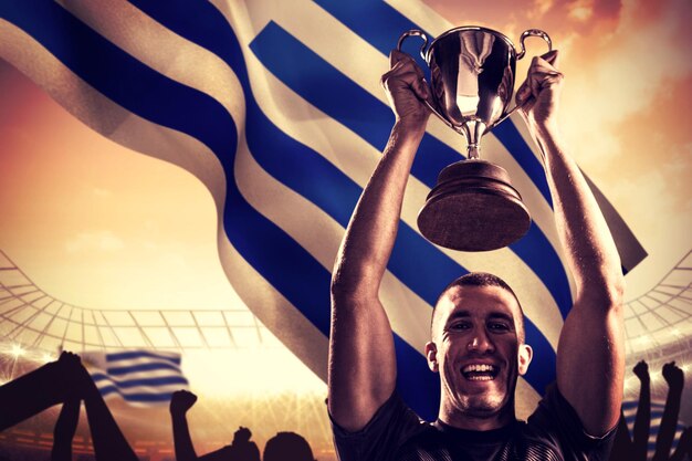 Foto imagen compuesta de retrato de exitoso jugador de rugby sosteniendo el trofeo