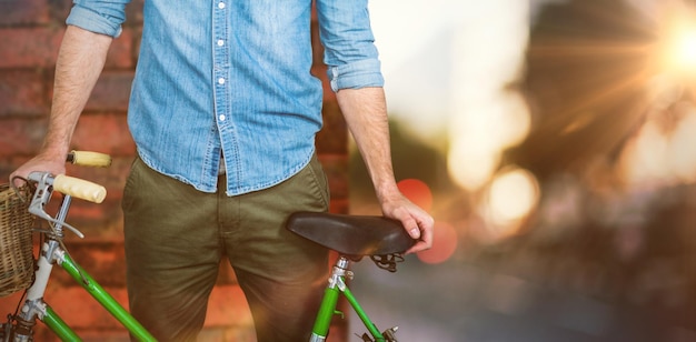 Imagen compuesta de retrato de hipster de pie con bicicleta