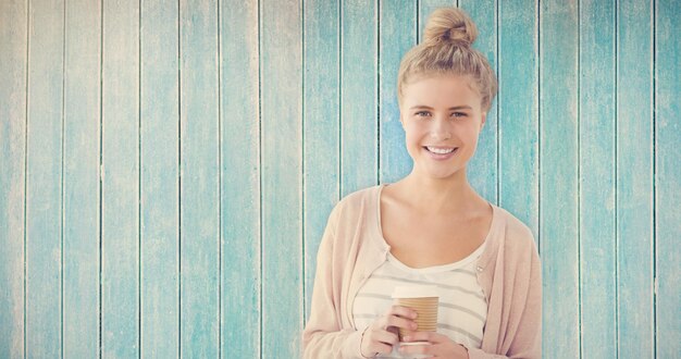 Imagen compuesta de retrato de mujer sonriente sosteniendo una taza de café