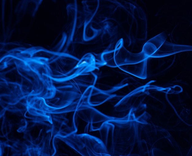 Imagen conceptual de humo de color azul aislado en negro oscuro