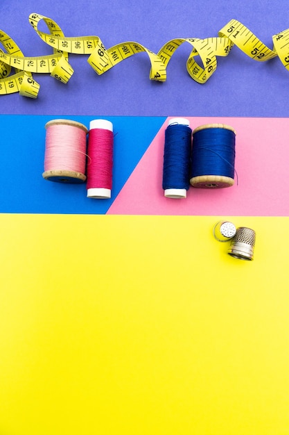Imagen creativa y vertical de suministros de costura sobre fondos coloridos