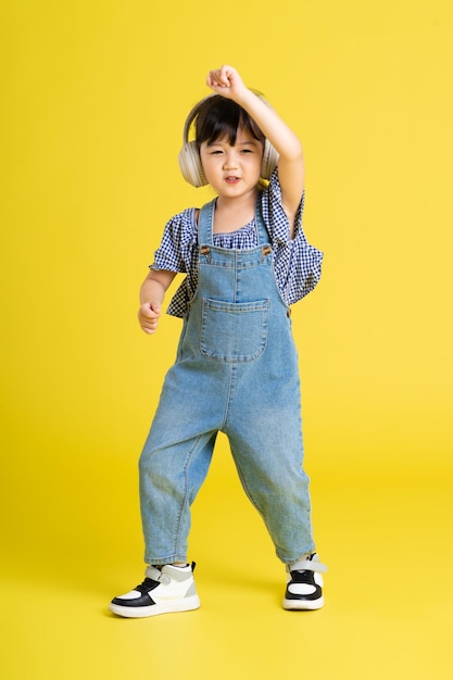 Imagen de cuerpo completo de hermosa niña asiática sobre fondo amarillo