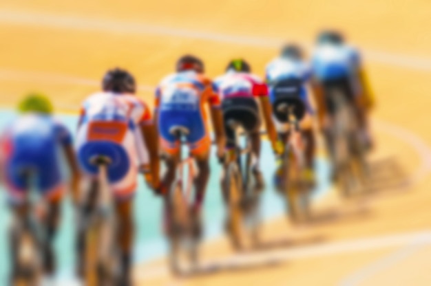 Imagen desenfocada de personas compitiendo con bicicletas en la pista