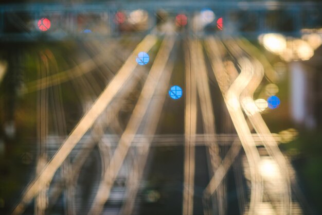 Imagen desenfocada de vías ferroviarias iluminadas por la noche