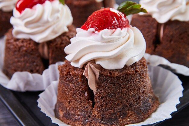 Imagen de Detalle de un delicioso cupcake de panadería relleno con glaseado y coronado con cereza