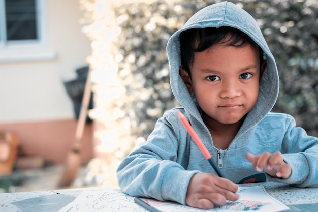 Imagen de dibujo de niño asiático lindo con crayón.