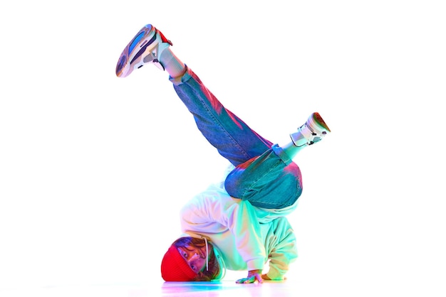 Imagen dinámica del hombre en su bailarín de hip hop en movimiento aislado sobre fondo blanco de estudio en