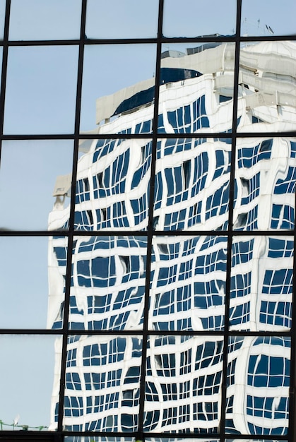 Foto imagen distorsionada de un rascacielos reflejada en ventanas espejadas