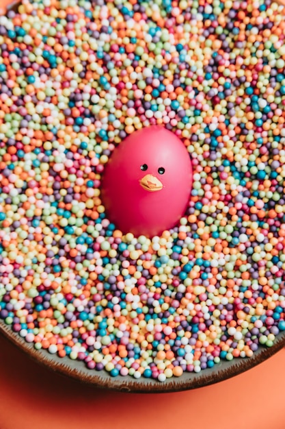 Imagen divertida de un juguete rodeado de bolas de colores, juguete de pato sonriente, concepto de fiesta con espacio de copia, día feliz, tarjeta postal de invitación